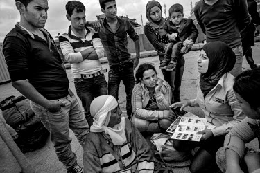 Refugees from Kobani receive emergency Mine Risk Education from MAG (Mines Advisory Group) as they arrive in Iraq from Turkey at the Ibrahim El Khalil crossing point. They will travel on to a refugee...