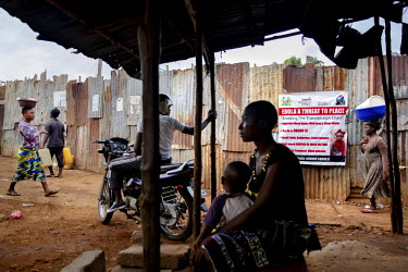 A poster on a wall in Kroo Bay states that ebola is a threat to peace and warns against virus spreading behaviours such as witchcraft and traditions such as washing the bodies of the dead.