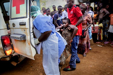 Isata Mansaray, 28, who is severely ill with ebola-like symptoms, is led, after a long wait, to a treatment facility in the Blackhall Road district. She died shortly afterwards and her family, who wer...
