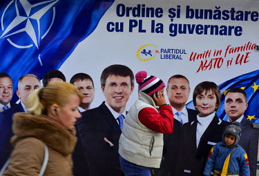 Pedestrians pass an election poster for a pro-EU political party taking part in the 30 November 2014  Moldovan Parliamentary elections.