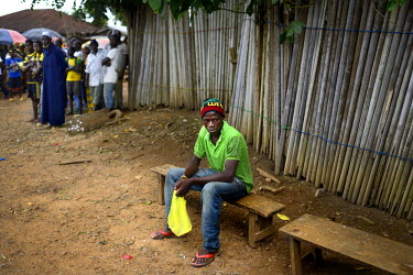 A man with the symptoms of Ebola sits on a bench in the main square of Dandano after the chief of the village, Siba Koevogui, ordered the crowd to 'Bring out your sick!...Don’t hide them!' The villa...