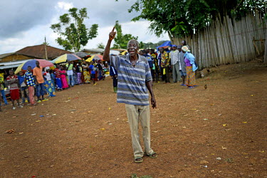 The chief of Dandano village, Siba Koevogui, yells at the crowd 'Bring out your sick!...Don’t hide them!' The village, isolated in the mountainous wooded Forest Region of Guinea, finally opened up t...