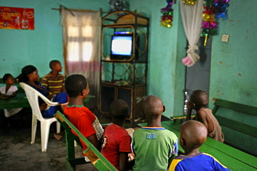 Children watch television in a bar in Macenta near the border with Liberia. Because of the ebola crisis schools have been closed since the beginning of the year.