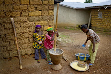 Children pound grains to make flour in Dandano village. The village, isolated in the mountainous wooded Forest Region of Guinea, finally opened up to the outside world and its inhabitants agreed to yi...