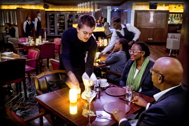 A couple are served by a 'Mzungu' waiter, at the newly opened Caramel Restaurant and Lounge, an upmarket establishment opened by Dubai's Caramel Group. Nairobi's restaurant scene has seen the recent a...