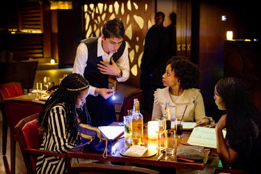 A group of young women enjoying a drink, served by a 'Mzungu' waiter, at the newly opened Caramel Restaurant and Lounge, an upmarket establishment opened by Dubai's Caramel Group. Nairobi's restaurant...
