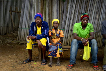 Pauline Sakou and two men with the symptoms of Ebola sits on a bench in the main square of Dandano after the chief of the village, Siba Koevogui, ordered the crowd to 'Bring out your sick!...Don’t h...