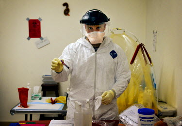 Lt. James Regeimbal Jr., from the American military, testing a blood sample at the Ebola Treatment Unit where they are testing the blood of all suspected ebola cases in Bong County. Phoebe (6) and Mar...