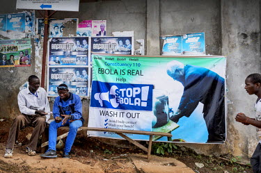 A banner on a wall warning people about ebola and showing a picture of the president, Ernest Bai Koroma, washing his hands.