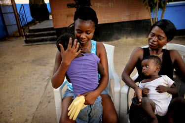 A caretaker, herself an ebola survivor, holds six year old Phoebe who has collapsed in tears after watching her sister Mary being taken by ambulance to the Ebola Treatment Unit. Mary was moved from th...