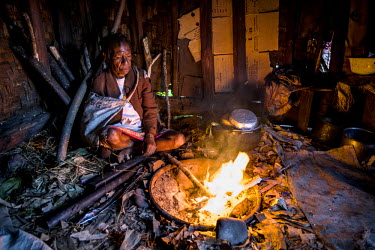 Mama Rasta tends a fire in her house. She was accused of sorcery by her neighbours after the death of a local young man. She was set upon by a crowd at his funeral and beaten and strangled before she...
