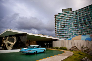 A vintage American car at the entrance of the 1950s built Hotel Habana Riviera, along the Malecon. Sculptor Florencio Gelabert designed the white marble sculptures, at left, of an intertwined mermaid...