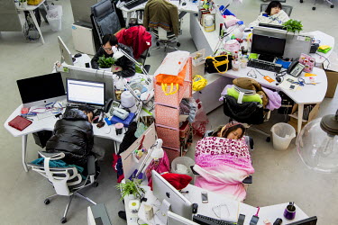 Employees take naps at their desks during lunch hour at the Wechat division of Tencent. Wechat is quickly becoming China's favorite social media tool and have already started to erode the income of in...