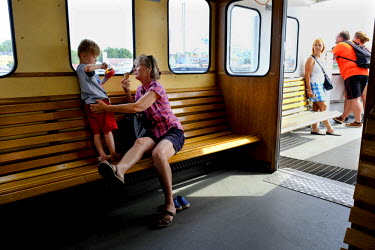 A mother enjoys an ice-cream with her son on one of the Stockholm's foot ferries that ply the waterways between the city's islands.