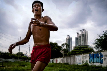 A man plays Takraw in an abanadoned lot.  Takraw is a game that combines elements of football and volleyball. ~<i>This is Bangkok</i> Globalised and localised.  Everyone is plugged into something. Cos...