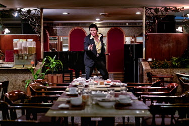 An Elvis impersonator stands in the dining area at the Asia Hotel in Bangkok. The hotel is favoured by Chinese tourists. The hotel also hosts American showtune shows performed by ladyboys. ~<i>This is...