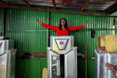 Therese Kirongozi, president of Women's Tech, stands behind an unfinished traffice robot in the workshop behind one of her other enterprises, a restaurant. Women's Tech designs and manufactures humano...