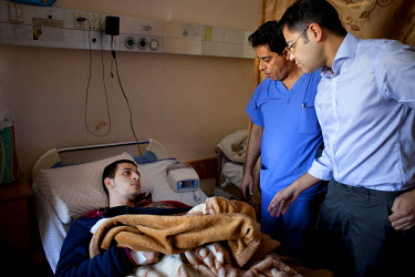 Ramy Zohod, a 19 year old from Al-Fakhora Jabalia, talks with Dr Naveen Cavale on a ward round post-op at the Shifa Hospital. On 7 July 2014, Israeli forces launched a large-scale military operation (...