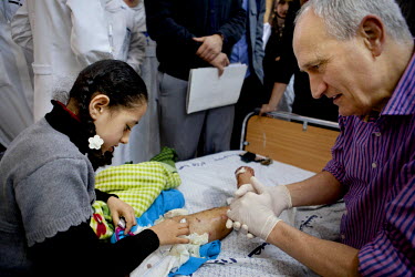 Weam Al Astal, a nine year old from Khan Younes, talks with her surgeon after undergoing surgery to treat serious injuries she received during the summer 2014 Israeli military operation ('Pillar of De...
