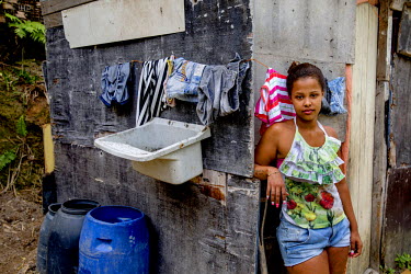 Lorena Ferreira Costa, 16, outside the bathroom at her mother's shack. Lorena has just moved to a nearby borrowed shack in Morro dos Mineiros hill, which is part of the Alemao Complex of favelas. She...