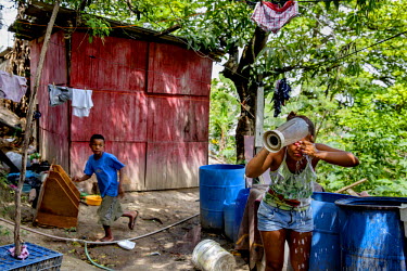 Lorena Ferreira Costa, 16, washung outside the bathroom at her mother's shack. Lorena has just moved to a nearby borrowed shack in Morro dos Mineiros hill, which is part of the Alemao Complex of favel...