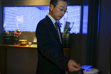 A man uses an electronic card at the Banshoji temple where, on the 3rd floor, there is a room called the Suishoden. In this hall, blue LEDs illuminate 2,000 small glass cinerariums, each containing a...