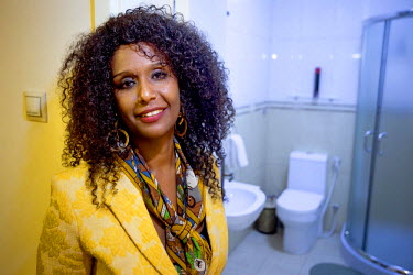 Doctor Amy Demissew, a returnee migrant, stands beside the toilet in her reonovated home.