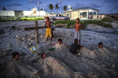 Children playing the 'Cemetery' game on one of the Ebeye's sandy beaches. The overpopulated island is informally known as the 'slum of the Pacific'. It people suffer numerous diseases and the mortalit...