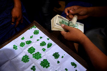 Jade dealers count money as they buy small, cut, jade stones for use in jewellery at the Jade Market in Mandalay.