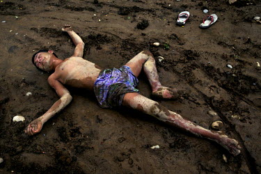 A man who appeared to be intoxicated (Unclear if he was intoxicated by drugs or alcohol) lies passed out at a spot frequented by heroin addicts on the banks of the Irrawaddy River.