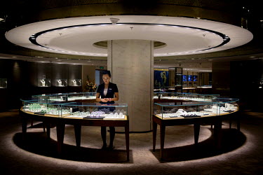 A saleswoman waits for customers at the 'Beijing Colourful Yunnan', a luxury jade emporium specialising in jade from Myanmar, in Beijing. Strong Chinese demand for Myanmar jade drives a booming market...
