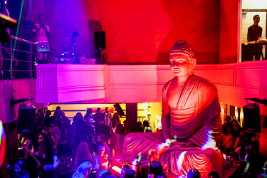 Revellers mingle around a giant Buddha statue at the Spice Route night club on Victoria Island.
