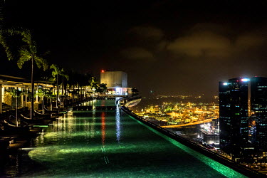 A view of the infinity pool at Skypark on the roof of the Marina Bay Sands Hotel overlooking the Singapore skyline. The SkyPark, 200m above ground level, is larger than three football pitches and has...