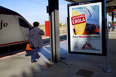 A businessman walks past a Medicos sans Frontieres poster appealing for donations to fund the campaign to fight Ebola in West Africa.