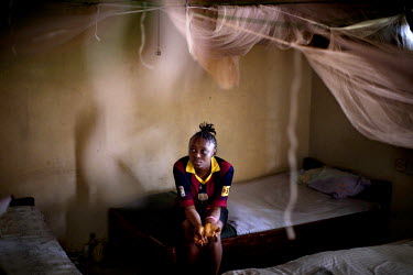 Betsy (12) sits on her bed. She survived the Ebola virus but lost many members of her family. She now lives in an orphanage.   Since the Ebola outbreak in Sierra Leone in 2014, about 3,500 people, inc...