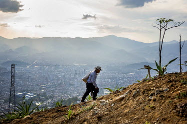 A farmer walks up a hillside near the 46 mile long concrete walking and cycling 'greenbelt' which encircles a valley on the edge of Medellin and is designed to curb urban sprawl. Not all residents are...
