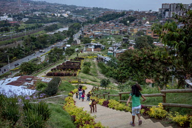 Residents walk the path to the top of the 'hill', a former rubbish dump turned into a garden. Since 2012, the city of Medellin has adopted an innovative project in the neighbourhood of Moravia to tran...