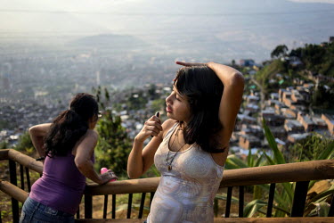 A young woman takes a break on a section of the 46 mile long concrete walking and cycling 'greenbelt' which encircles a valley on the edge of Medellin and is designed to curb urban sprawl. Not all res...