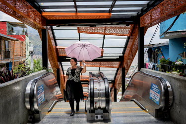 A woman leaves the 384-metre-long escalator in Comuna 13, the most dangerous district in Medellin. In 2006, the city built a public library, a new school, public green spaces, and improved access to t...