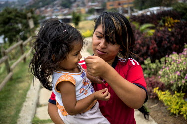 Marta Chica Lopez, 27, and Luciana, 2, walk through the garden that was once a garbage dump in the neighbourhood of Moravia, where she grew up. Marta lives in a two-story house that her grandfather bu...