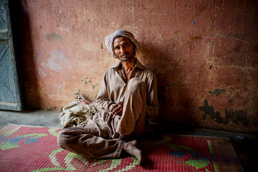 A Babaria man sits on the floor in a house in Panipat.   The Babaria are a major source of illegally traded tiger parts since they used to hunt them when it was legal to do so and now sell them to tra...