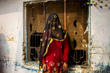 A woman belonging to the Babaria caste stands next to a delapidated building in Panipat. The Babaria are a major source of illegally traded tiger parts since they used to hunt them when it was legal t...