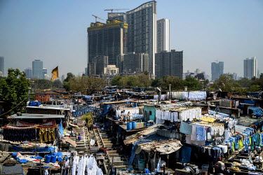 Tower blocks, under construction, loom over Dhobighat. This is an open air area where 'dhobis' wash the laundry for all strata of the city's society. It is here that, by hand, laundry, from hospital s...