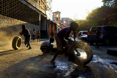 Children play with old car tyres on a quiet street in Hillbrow, an inner-city neighbourhood with a reputation for drugs, violence and crime. The children fill the tyres with gravel and sand, which mak...