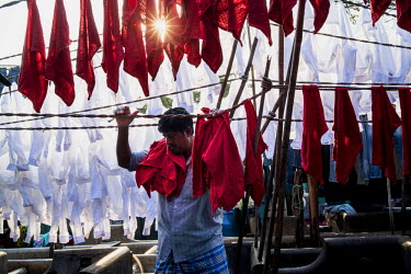 A man hangs out cloths to dry in Dhobighat, the open air area where the city's laundry is washed by an army of dhobis (laundry person). It is here that the laundry for all strata of the city's society...