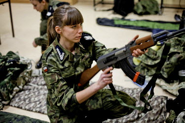 Kamilla, 17, a young member of Strzelec (The Shooter), a paramilitary association, examines a replica rifle during a training weekend. Several paramilitary groups from the region joined together to ta...
