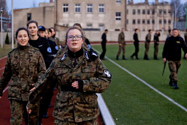 Weronika, 17, a young member of Strzelec (The Shooter), a paramilitary association, sings as she leads a group of youths training on the playing field of a local school. The weekend saw a gathering of...