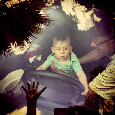 Victor Gachet plays with his grandson, Nahuel, in the front seat of a car.