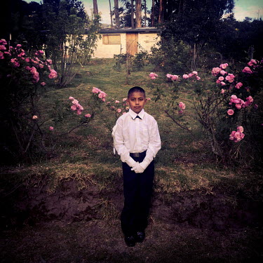 Andres Achance, 11, stands in front of his house before walking to the local church for his first communion ceremony.