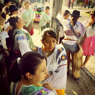 Teachers and parents of children from a local school prepare to dance in the street for the fiestas of Tumbaco. They are wearing traditional clothing from Cayambe.
